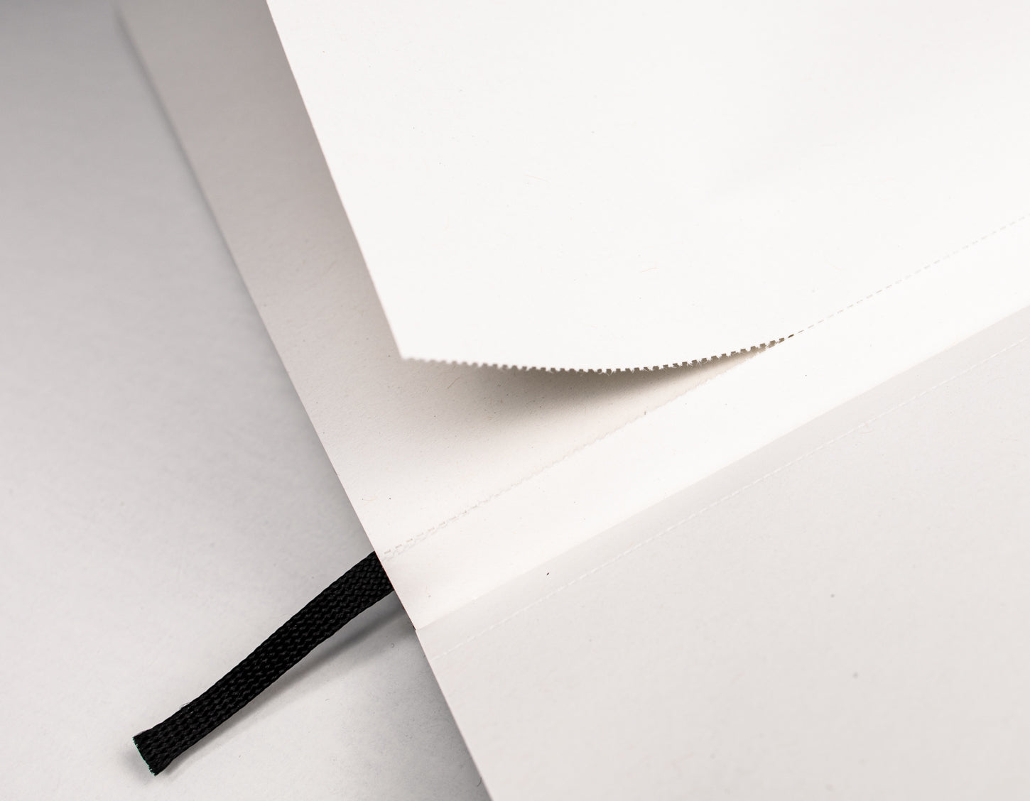 Blanko Innenseiten eines Notizbuchs mit heraustrennbaren Seiten und Leseband, ideal für Skizzen und Konzepte